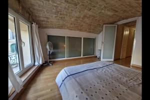 a bedroom with a large bed and a large window at Superbe Appartement Rénové - Centre Historique in Montpellier