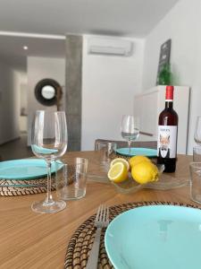 a wooden table with glasses and a bottle of wine at Apartamento El Tassolet in Jalón