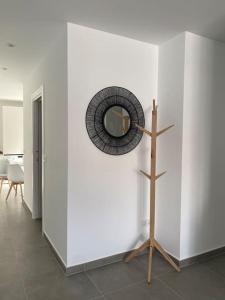 a mirror on a white wall with a wooden pole at Apartamento El Tassolet in Jalón