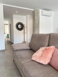 a living room with a couch with a pink furry pillow at Apartamento El Tassolet in Jalón