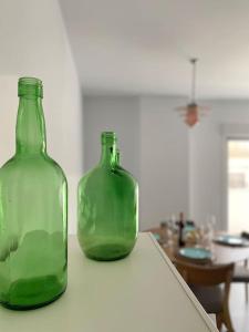 two green glass bottles sitting on top of a counter at Apartamento El Tassolet in Jalón