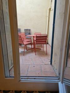 a view of a patio with chairs and a table at Les Arènes in Arles
