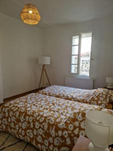 um quarto com uma cama, um candeeiro e uma janela em Les Arènes em Arles