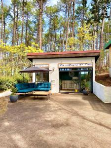 quelques chaises bleues assises devant un bâtiment dans l'établissement LES COTTAGES DE LEON, à Léon