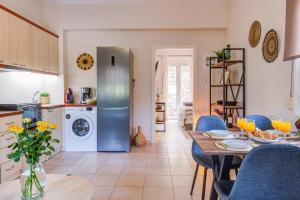 een keuken en eetkamer met een tafel en een koelkast bij Eleanna's House - 400m From the Beach in Rethimnon