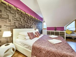 ザコパネにあるVisitZakopane - Nepal Apartmentの紫色のアクセントの壁のベッドルーム1室