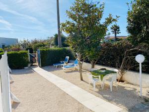 a patio with a table and chairs and a tree at Dimora al Mare in Villanova di Ostuni