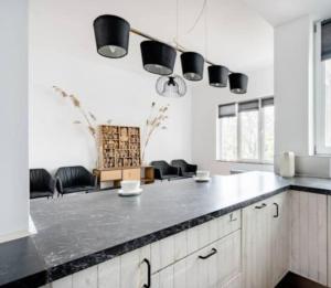 a kitchen with a black counter top and some chairs at Family townhouse 3 bedrooms in Brussels