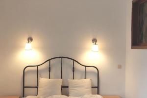 2 luces en la parte superior de una cama con 2 almohadas en Family townhouse 3 bedrooms, en Bruselas