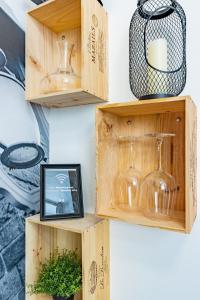 un conjunto de cajas de madera con copas de vino y una foto en L'Industriel - Appart'Hôtel SPA - Clim - Melina & Alfred Agen, en Agen