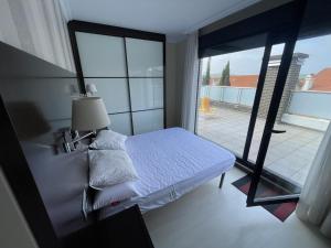 een slaapkamer met een bed en een glazen schuifdeur bij Atardecer en Miengo in Miengo