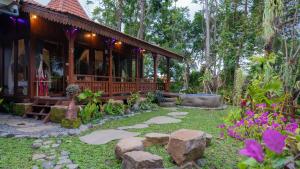 een tuin voor een huis met rotsen bij Homayoon Private Villa Ubud in Ubud