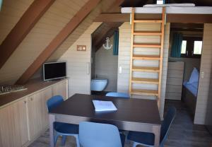 a dining room with a table and chairs in a tiny house at Chalet im See- Nr 44 in Rust