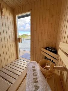 a wooden cabin with a door to a window at Hausboot Fjord Schleiliebe mit Biosauna und Dachterrasse in Schleswig in Schleswig