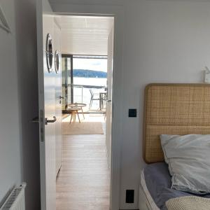 Hausboot Fjord Schleiliebe mit Biosauna und Dachterrasse in Schleswig في شلسفيغ: غرفة نوم مع باب مفتوح على غرفة نوم مع سرير