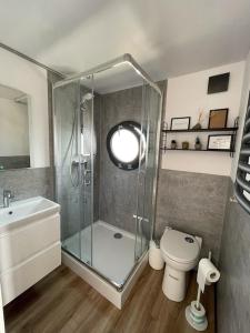 uma casa de banho com um chuveiro, um WC e um lavatório. em Hausboot Fjord Schleiliebe mit Biosauna und Dachterrasse in Schleswig em Schleswig