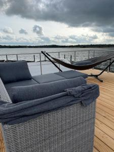 un sofá sentado en la cubierta de un barco en Hausboot Fjord Schleiliebe mit Biosauna und Dachterrasse in Schleswig en Schleswig