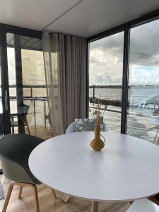 - une table et des chaises blanches avec vue sur l'océan dans l'établissement Hausboot Fjord Schleiliebe mit Biosauna und Dachterrasse in Schleswig, à Schleswig