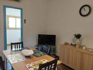 a dining room with a table and a clock on the wall at CASA SIRENETTA-Little Mermaid House in Lentini