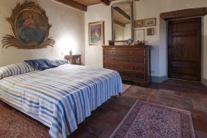 - une chambre avec un lit, une commode et un miroir dans l'établissement Sillicagnana Castle Villa with Swimming Pool!, à San Romano