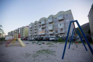 einen Spielplatz mit einem Haufen Schaukeln vor Gebäuden in der Unterkunft Apartment Cejf Mostar in Mostar