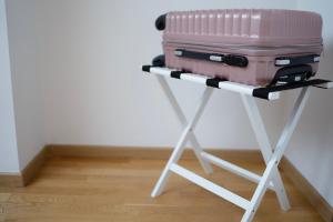 Une valise rose est assise sur un support dans l'établissement Apartment Cejf Mostar, à Mostar