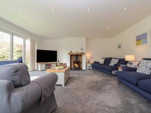 a living room with two blue couches and a fireplace at Little Chapter in Southwold