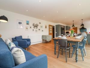 a living room with a blue couch and a table at Little Chapter in Southwold