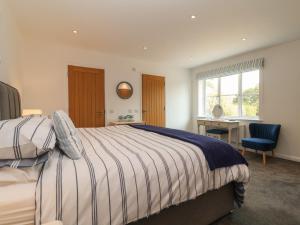 a bedroom with a bed and a desk and a chair at Little Chapter in Southwold