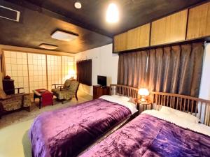 1 dormitorio con 2 camas, sofá y silla en 酒と宿と不動産-yado- en Yokosuka