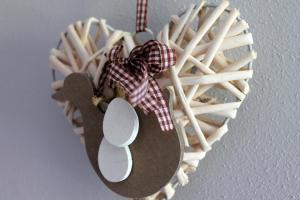 une décoration en osier en forme de cœur sur un mur dans l'établissement CASA YARA - appartamento moderno, Dolomiti Affitti, à Cavalese