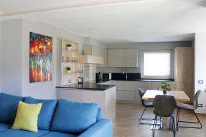 sala de estar con sofá azul y cocina en CASA YARA - Dolomiti Affitti en Cavalese