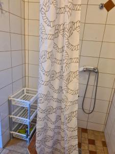 a shower curtain in a bathroom with a shelf at DOM SABINA in Krynica Morska