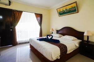 Postel nebo postele na pokoji v ubytování Taman Ayu Legian Hotel