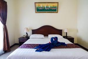 Postel nebo postele na pokoji v ubytování Taman Ayu Legian Hotel