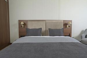 um quarto com uma cama grande e uma cadeira em Moncher Hotel em Tuzla