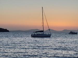 a sail boat in the water at sunset at Swing in Corfu