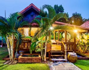 a house with two palm trees in front of it at Thai House Resort in Hua Hin