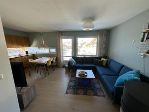- un salon avec un canapé bleu et une table dans l'établissement Sinnestunet 201A, à Tjørhom
