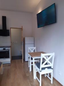 a kitchen with a table and two chairs and a television at Apartament Klimt 1 in Bielsko-Biała