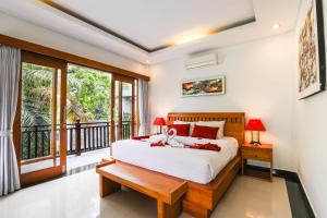 a bedroom with a bed and a balcony at Amoya Inn in Ubud