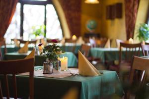 Gasthof Sondergeld في Hofbieber: غرفة طعام مع طاولات خضراء وكراسي مع شموع