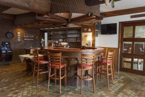bar w restauracji z drewnianymi stołkami w obiekcie Gasthof Sondergeld w mieście Hofbieber