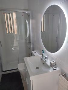 een witte badkamer met een wastafel en een spiegel bij PENTHOUSE LA VICTORIA Parking Gratis in Málaga