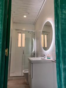 een badkamer met een wastafel, een toilet en een spiegel bij PENTHOUSE LA VICTORIA Parking Gratis in Málaga