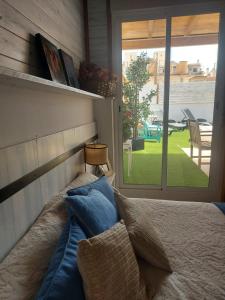 een bed met blauwe kussens in een kamer met een raam bij PENTHOUSE LA VICTORIA Parking Gratis in Málaga