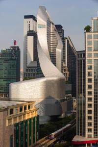 a large building in a city with tall buildings at Park Hyatt Bangkok in Bangkok