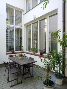 un patio con mesa, sillas y ventanas en Apartments Villa OLGA, en Leópolis