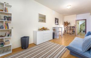 a living room with a blue couch and bookshelves at Nice Apartment In Stara Baska 1 With Wifi in Stara Baška