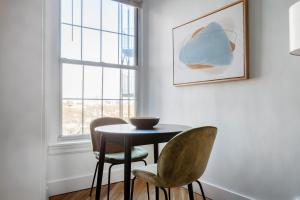 a table and two chairs in a room with a window at Brookline Studio w Gym nr Green Line BOS-476 in Brookline